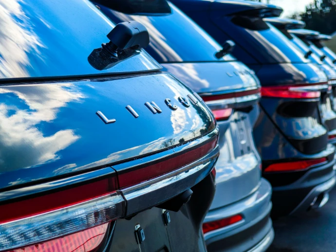 Row of shiny black lincoln suvs reflecting the sky